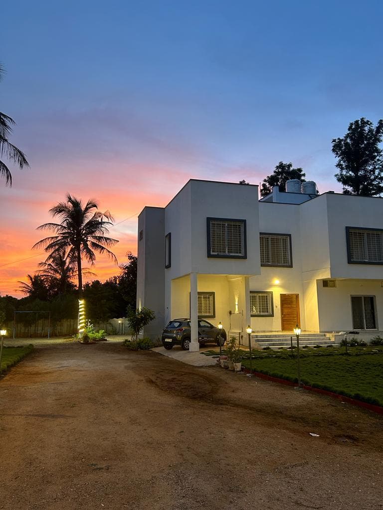 Saaz Farmhouse at sunset with palm trees