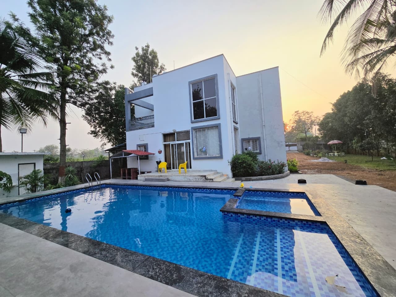 Saaz Farmhouse — poolside view at sunset